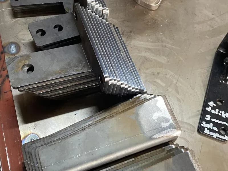 Kaynak masasında istiflenmiş, lazerde kesilmiş bağlantı parçaları